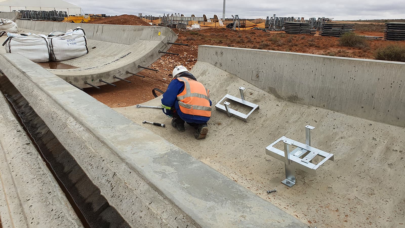 Quebar civil team installing fittings in a concrete channel